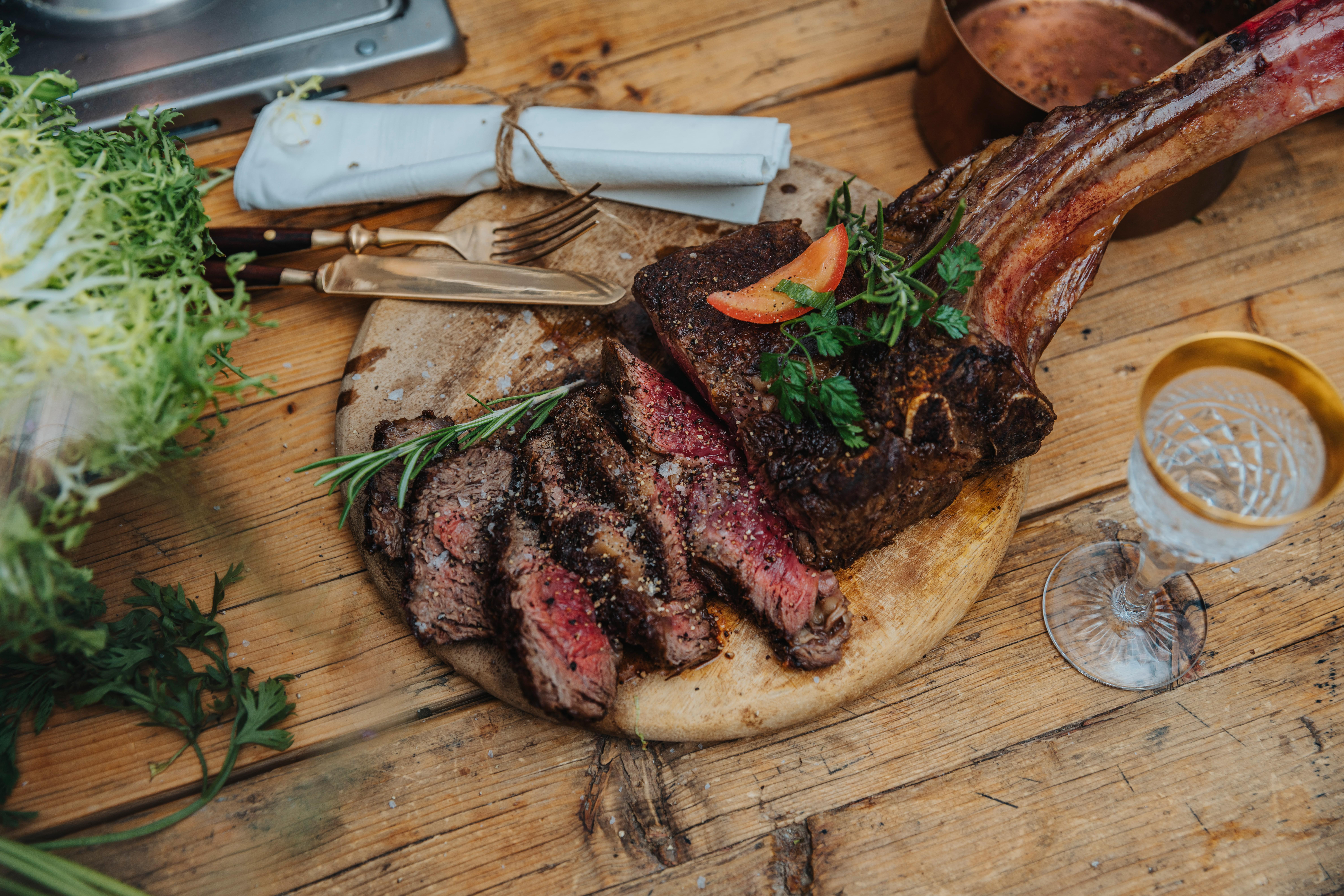 Whole grilled and seasoned tomahawk steak on wooked board, Koeln, NRW, Germany