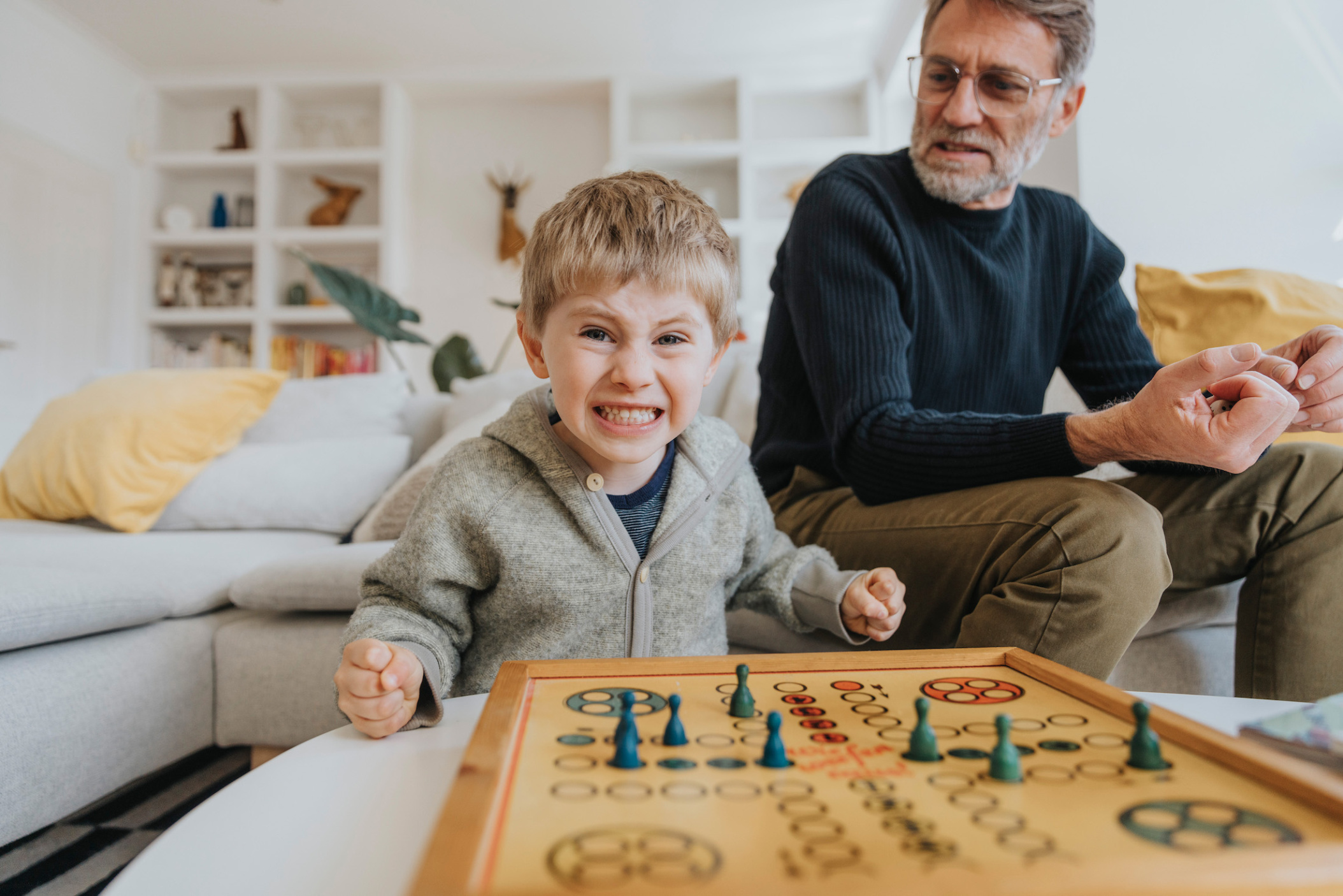 Son winning against his father while playing a board game at home, Viersen, NRW, Germany