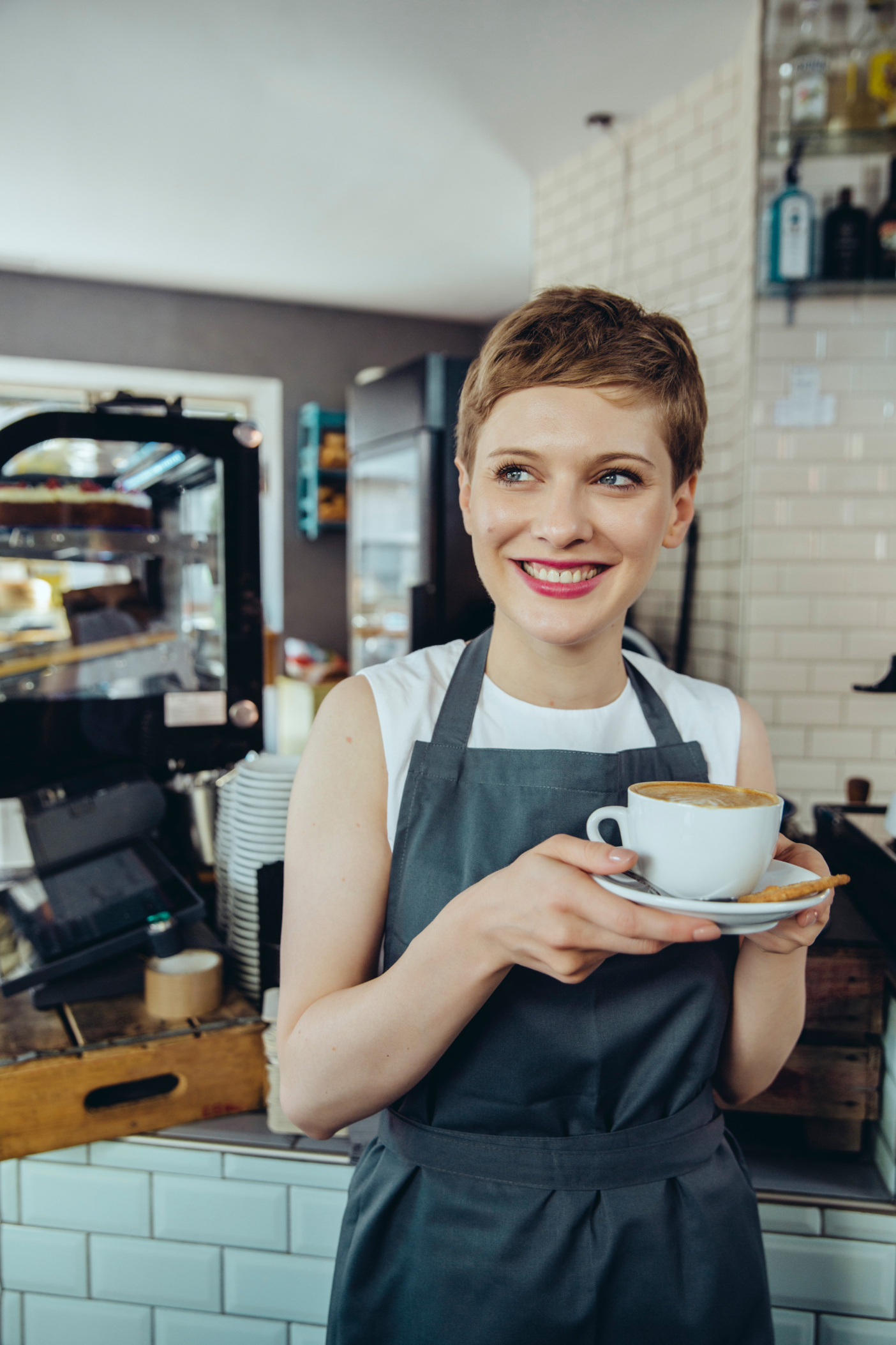 Waitress or cafe owner holding cup of coffee, Cologne, NRW, Germany