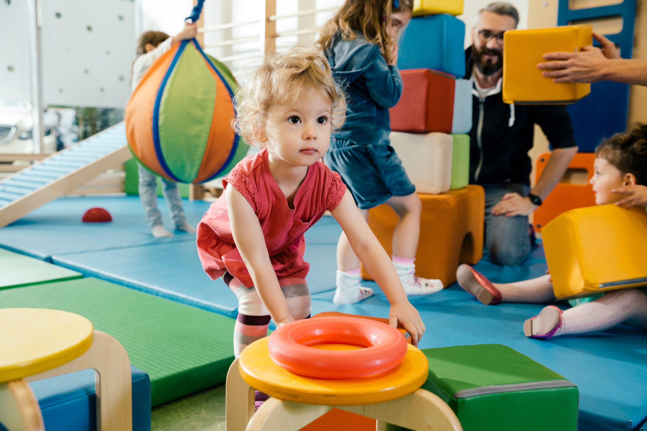 Small girl playing in gym room of  Daycare center, Pre-school or Kindergarten, Cologne, NRW, Germany