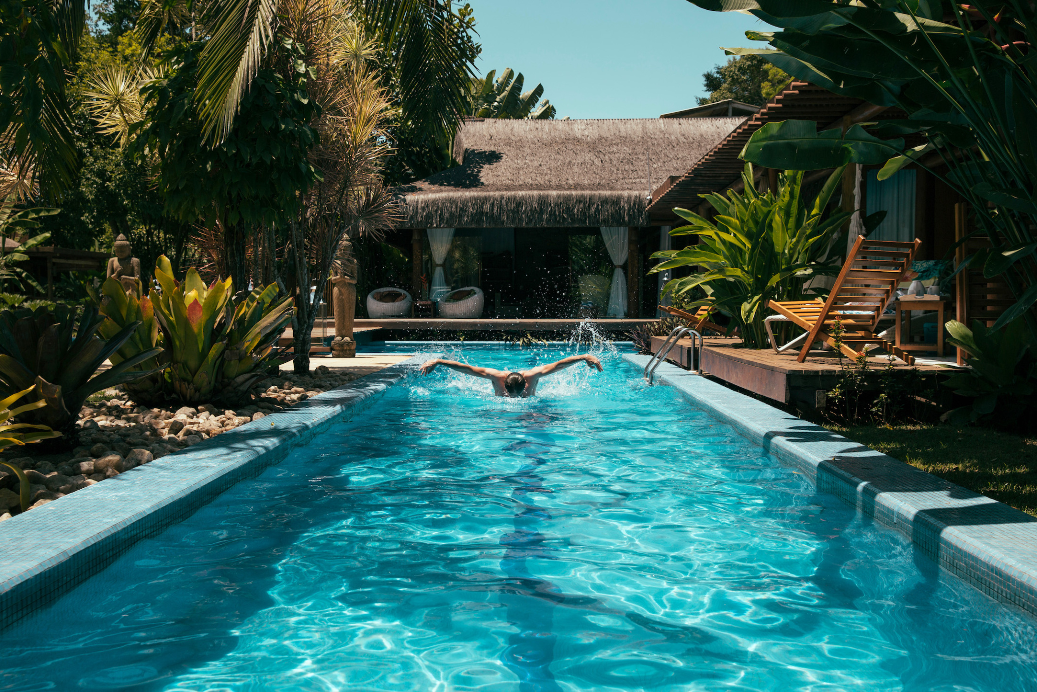 Man swimming in swimming pool of Bali style hotel, Porto Seguro, Bahia, Brazil
