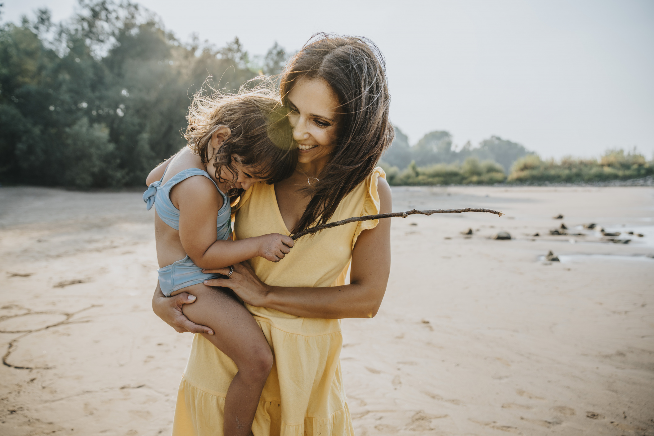 Mother holding her daughter in her arms at the beach, Cologne, NRW, Germany