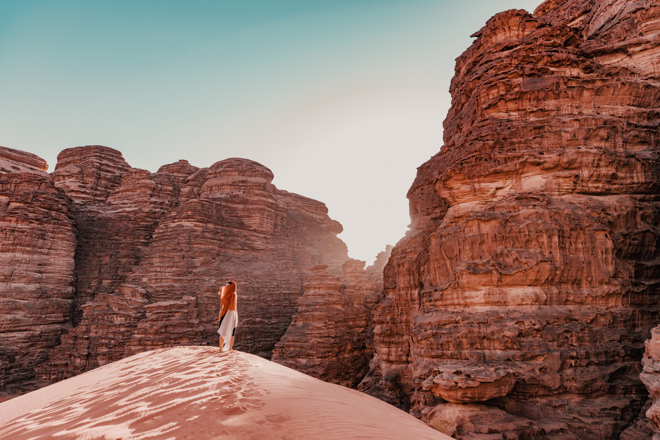 NEOM, SAUDI ARABIA – DECEMBER 9: Woman standing on a Hisma Desert sand dune on December 09, 2022, in NEOM, Saudi Arabia.