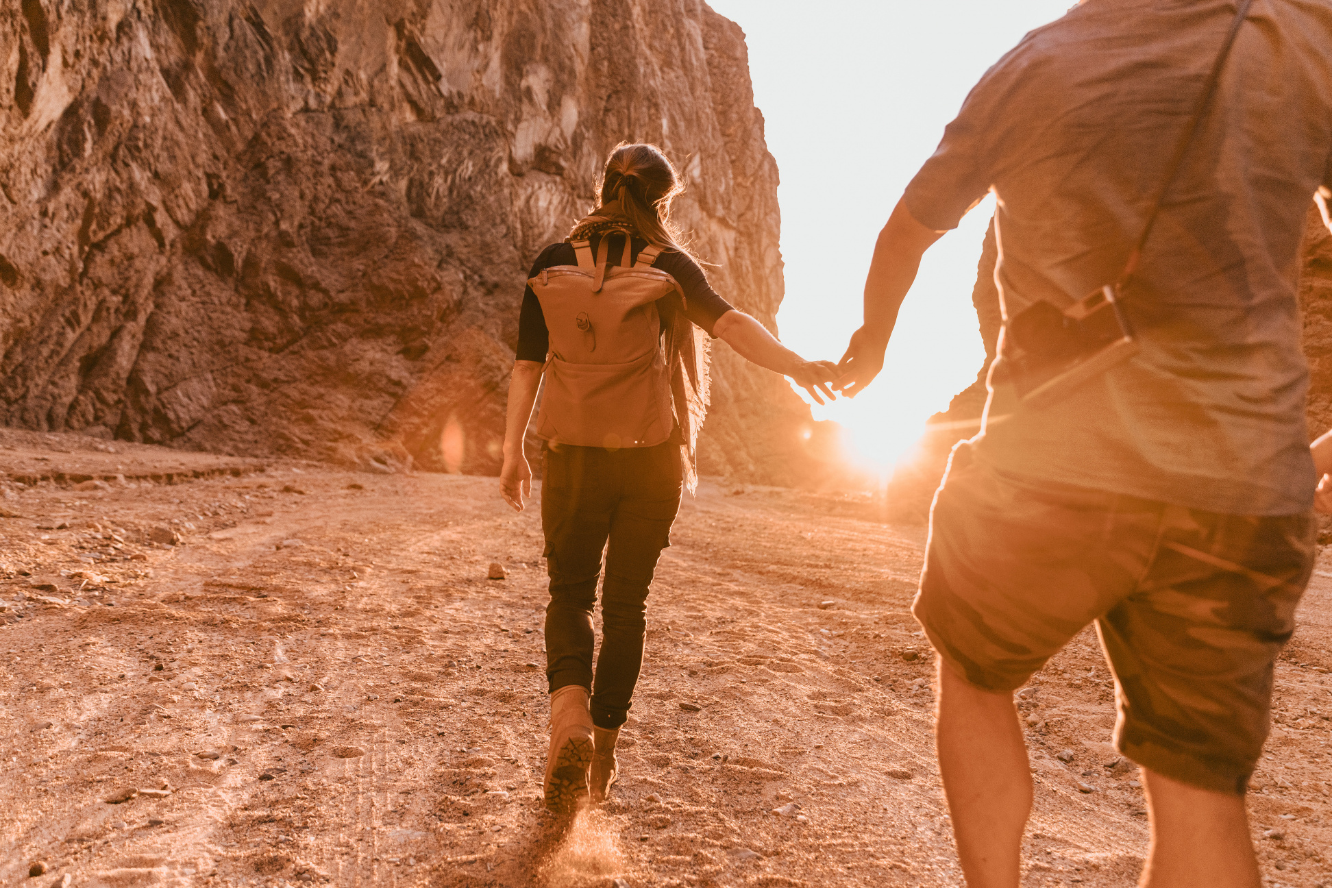 NEOM, SAUDI ARABIA – DECEMBER 11: Explorer couple walking into sunset in Wadi Tayyib Al Ism on December 11, 2022, in NEOM, Saudi Arabia.