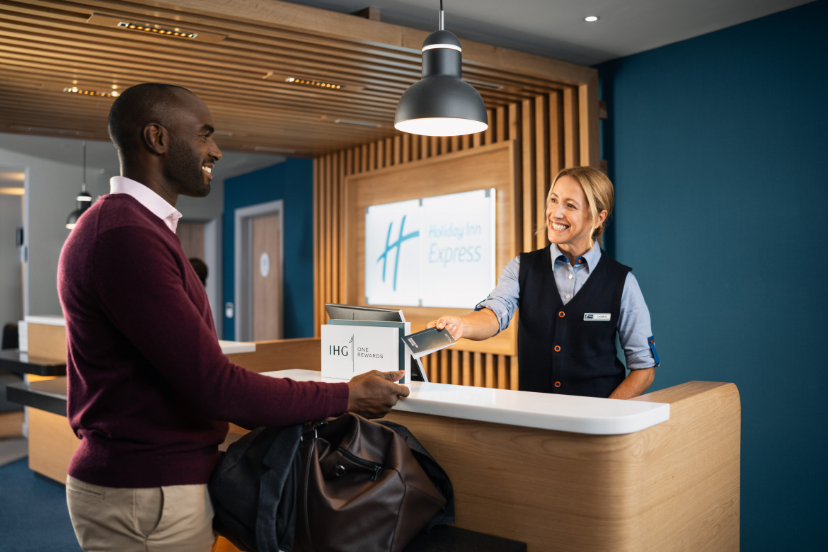 Guest checking in at Holiday Inn Express front desk by Mareen Fischinger