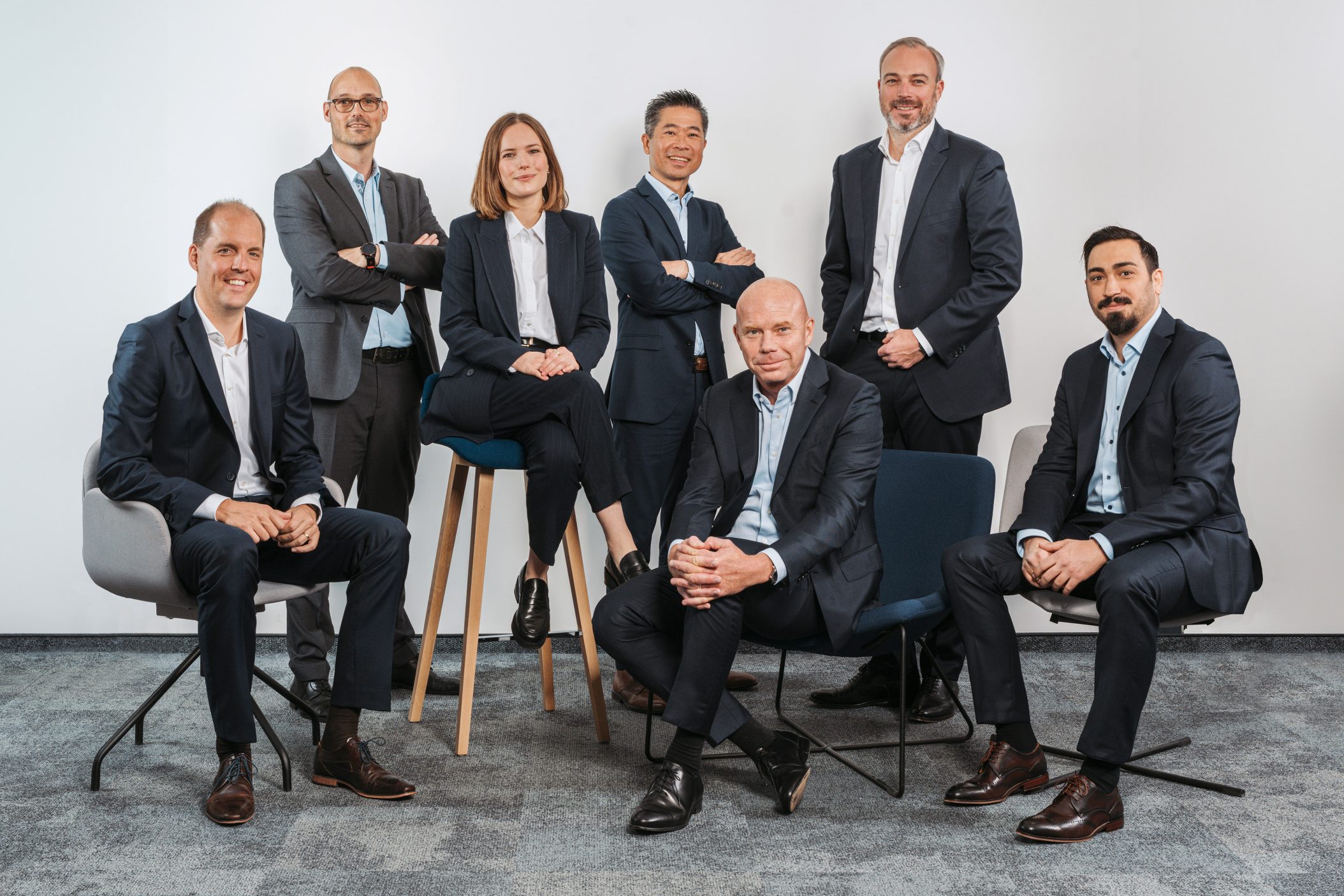 Siebenköpfiges Geschäftsteam in Business-Kleidung posiert professionell