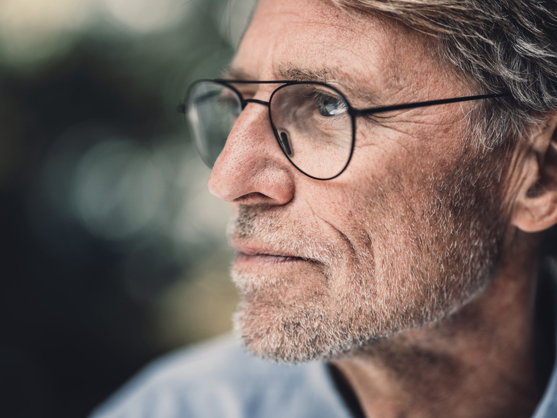 Nachdenklicher älterer Mann mit Brille und grauem Bart